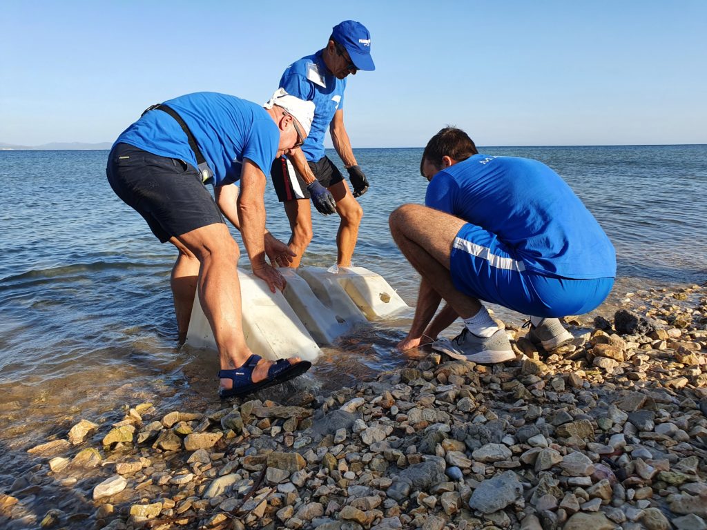 Raccolta di un rifiuto ingombrante dalla spiaggia di Is Pruinis